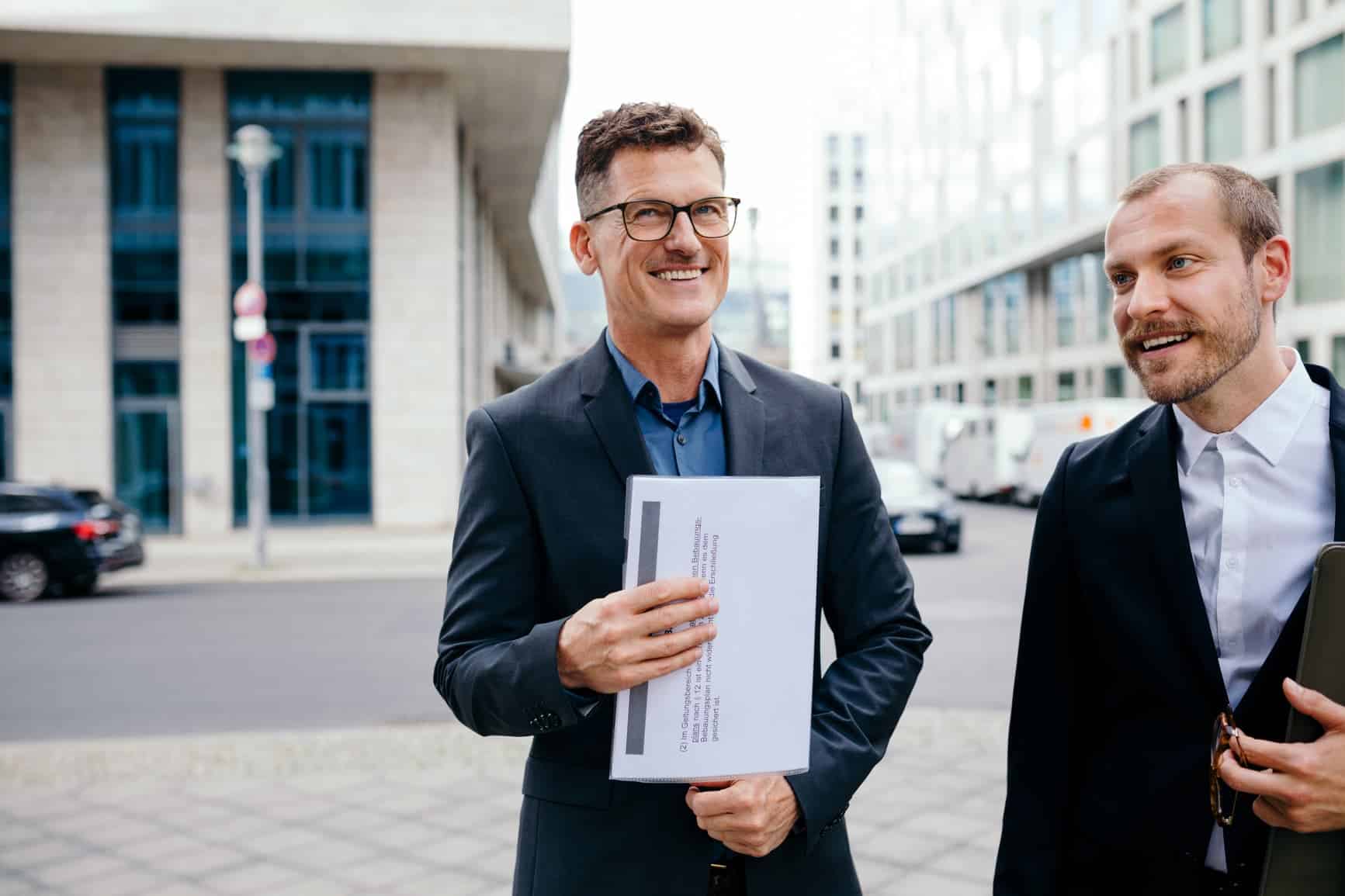 Professionella kollegor i kostym som är glada och representerar starkt ledarskap